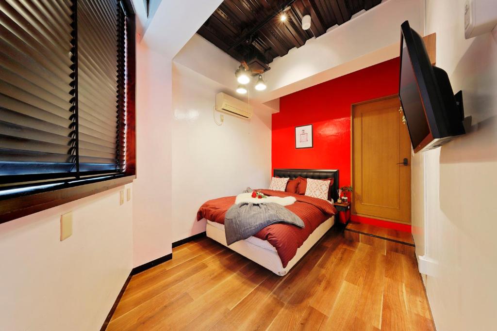 a red bedroom with a bed and a flat screen tv at Terrace Terano#101 in Tokyo