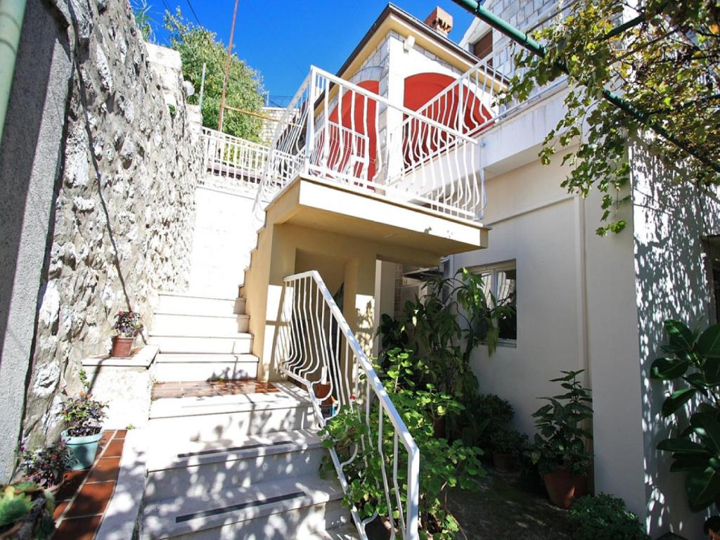 a white house with stairs and a balcony at Rooms Vjera in Dubrovnik