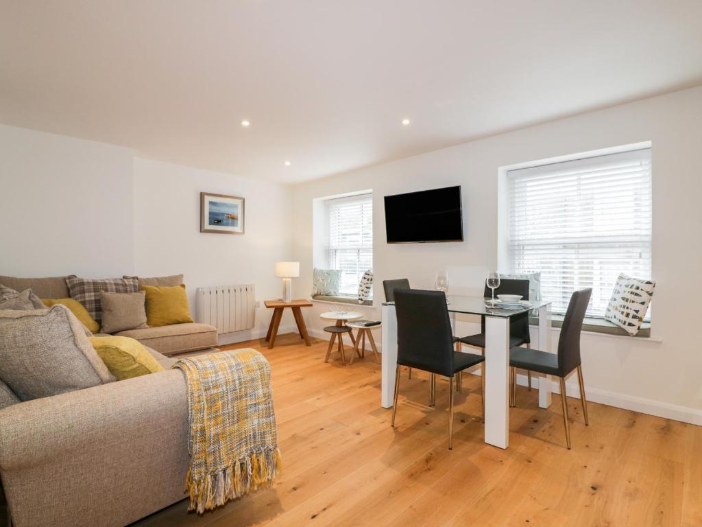 a living room with a couch and a table at Midships in St Austell