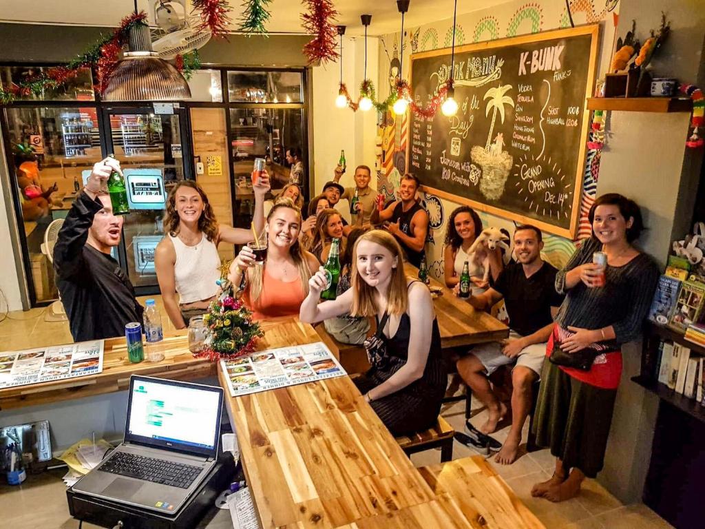 um grupo de pessoas sentadas numa mesa num bar em K-Bunk Hostel em Praia de Aonang