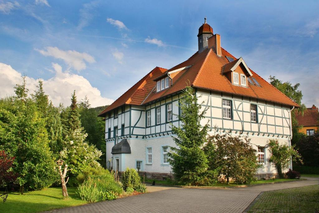 una gran casa blanca con techo naranja en Ferienwohnung Hoff, en Göllingen