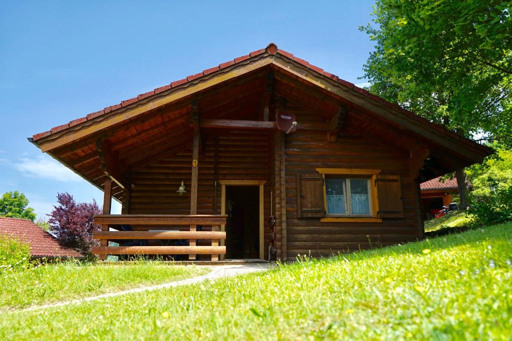 a log cabin with a door in a field of grass at Blockhaus Noffke in Stamsried