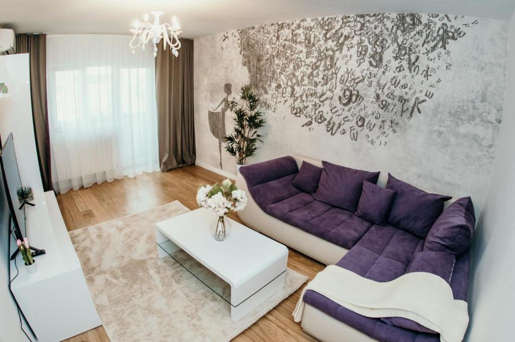 Apartament de lux ultramodern in zona centrala في تيميشوارا: غرفة معيشة مع أريكة أرجوانية وطاولة
