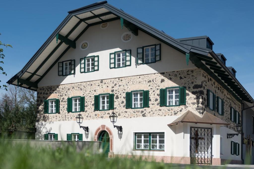 ein Haus mit grünen Rollläden auf einem Gebäude in der Unterkunft Sauerweingut in Salzburg