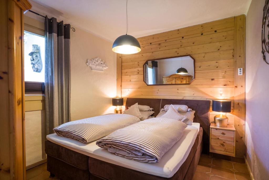 a bedroom with a bed with a wooden wall at Chalet Grizzly in Ellmau