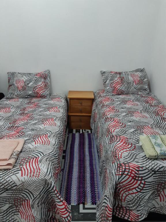 two beds sitting next to each other in a room at kitnet Maysa em Benfica RJ in Rio de Janeiro