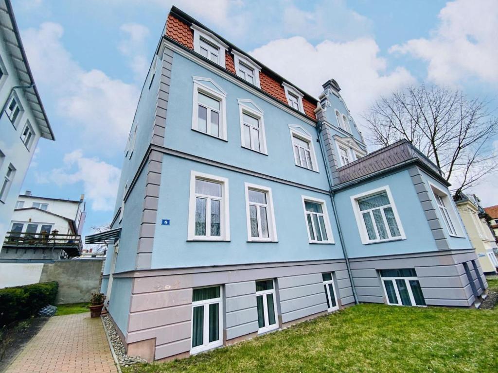 uma grande casa azul e branca num quintal em Riga em Warnemünde