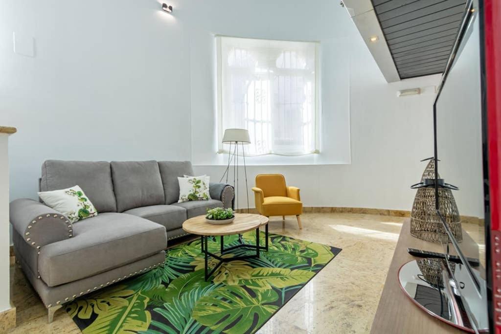 een woonkamer met een bank en een tafel bij Becas Alameda Duplex by Valcambre in Sevilla