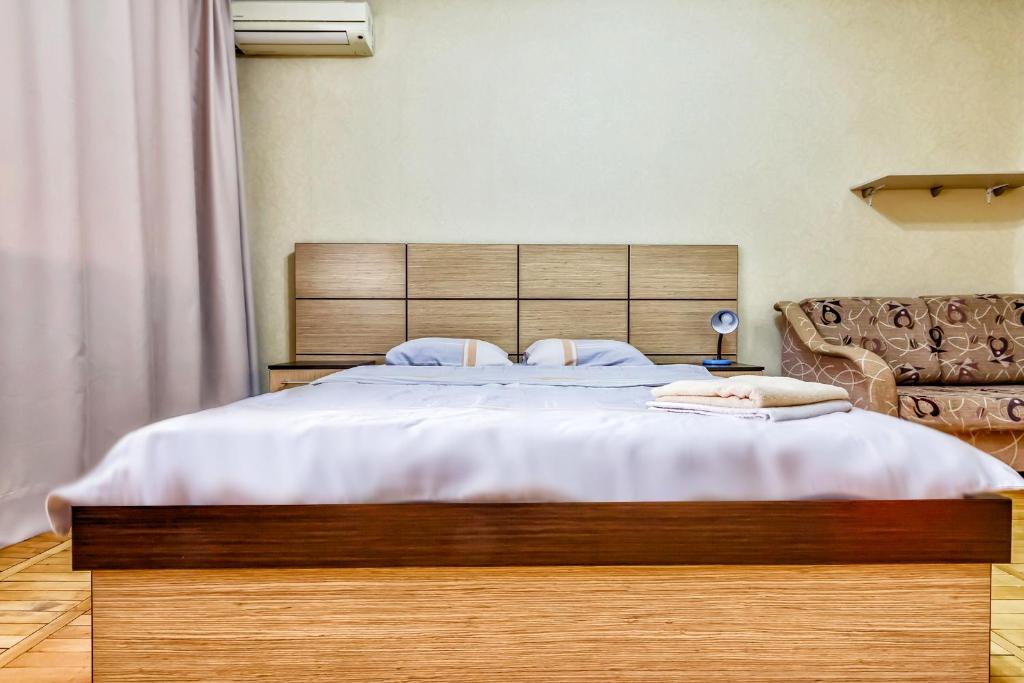 a bedroom with a large bed with a wooden headboard at 430 Апартаменты в Золотом квадрате в центре Отличный вариант для туристов и командированных in Almaty