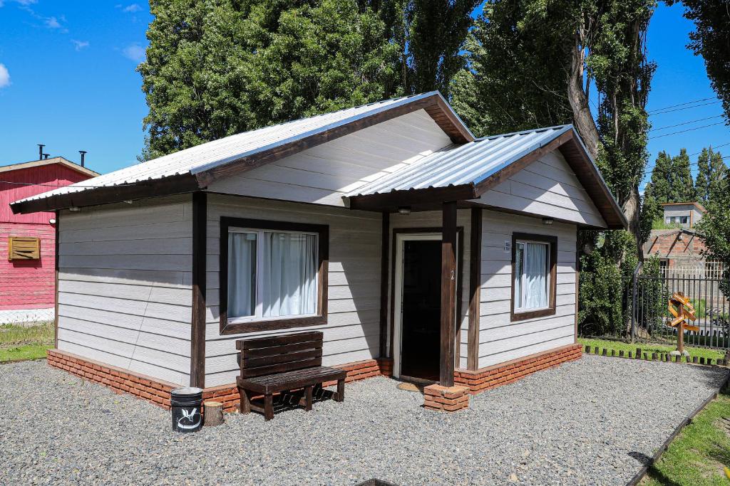 un pequeño cobertizo con un banco delante de él en Cabañas del Arroyo Calafate (CRyPPSC) en El Calafate