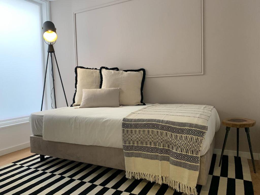 a bedroom with a bed and a lamp and a window at Casa do Museu, Museum House in Coimbra