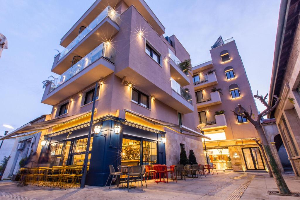 a building with tables and chairs in front of it at Old Port Hotel in Limassol