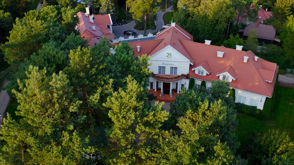 Baśniowa في فيشكوف: منزل كبير وسقف احمر فوق الاشجار
