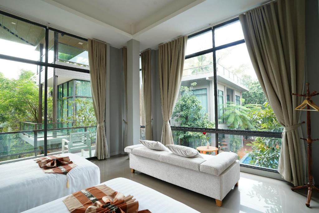 sala de estar con 2 camas y ventana grande en Treescape Resort Chiangmai, en Chiang Mai