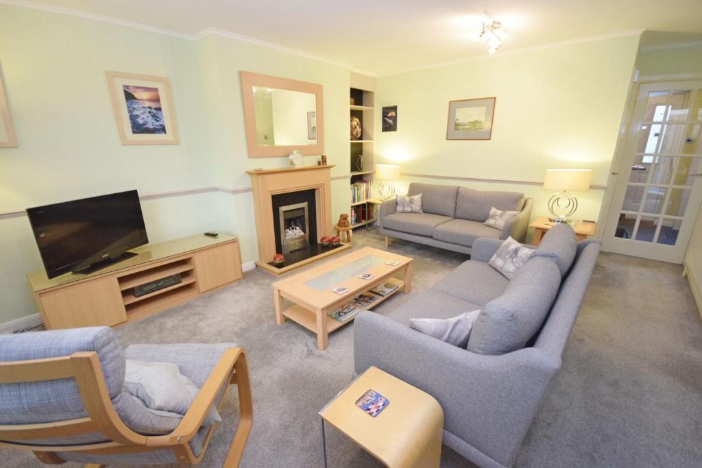 uma sala de estar com dois sofás e uma televisão em Orchard Mews , Barnham em Barnham