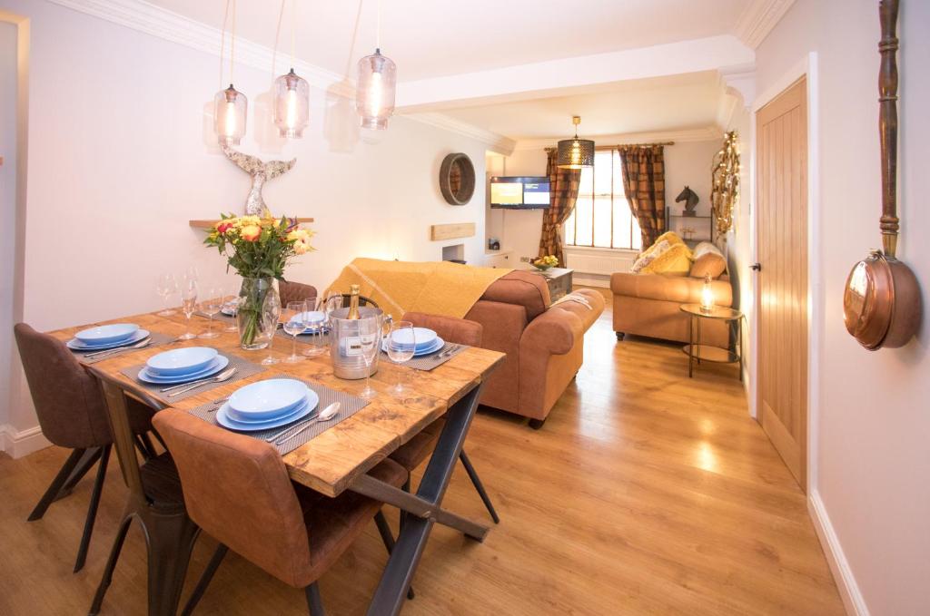 a dining room and living room with a table and chairs at 43 BBEscapes in Merthyr Tydfil