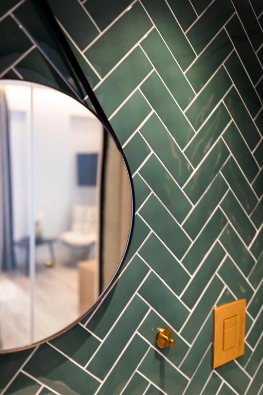 a green tiled wall with a mirror in a room at Old Port Hotel in Limassol