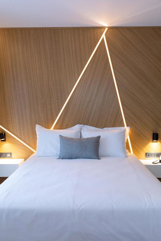 a large bed with white pillows in a room at Old Port Hotel in Limassol