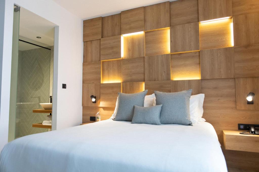 a bedroom with a large bed and wooden wall at Old Port Hotel in Limassol