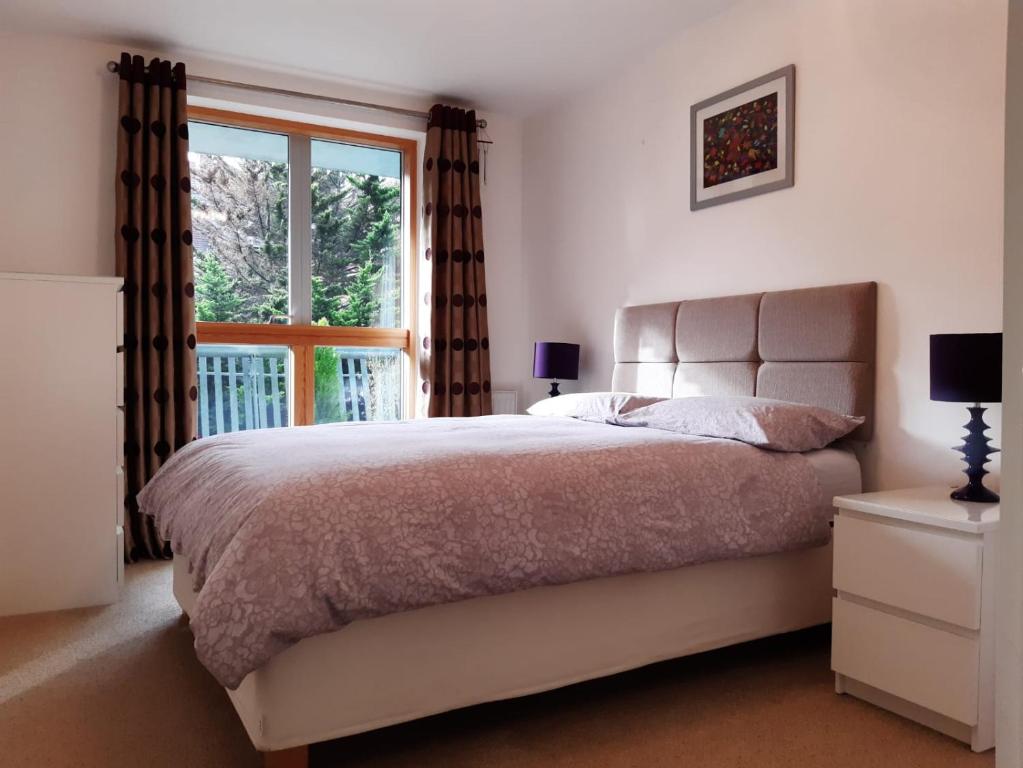 a bedroom with a large bed and a window at Stylish Wembley Stadium and SSE Arena Apartment, London in London