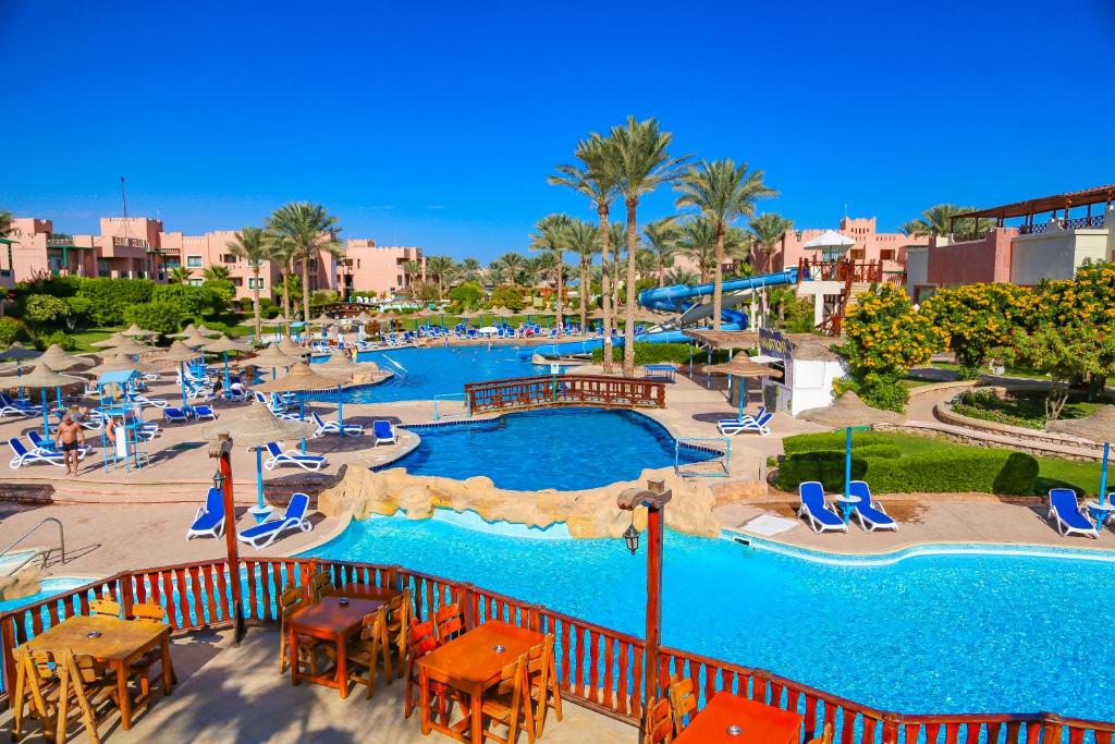 een resort met een groot zwembad met stoelen en tafels bij Rehana Sharm Resort - Aquapark & Spa - Couples and Family Only in Sharm El Sheikh