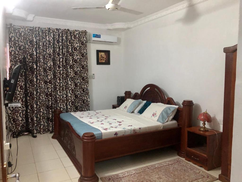 a bedroom with a bed and a curtain at Michenzani Flat in Zanzibar City