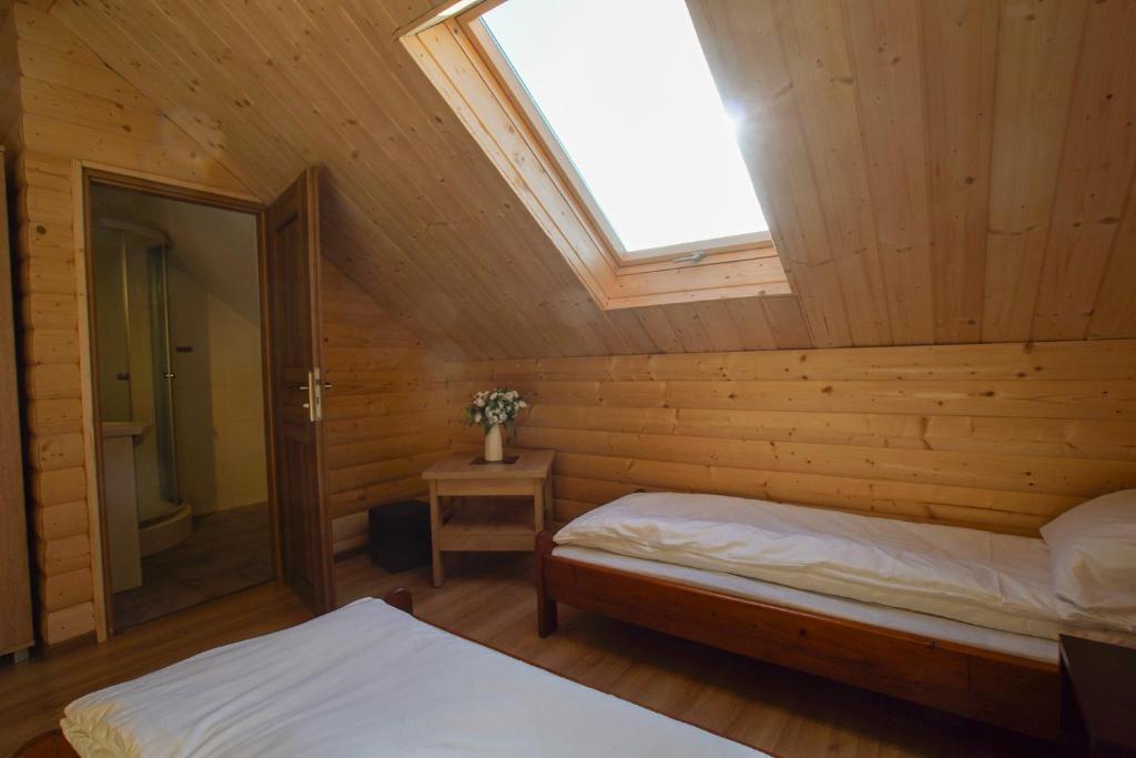 a bedroom with a skylight in a wooden cabin at Górska Chata u Kota in Huta Szklana
