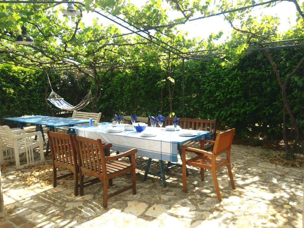 a table with three chairs and a blue table cloth at Apartments Ivas in Zambratija