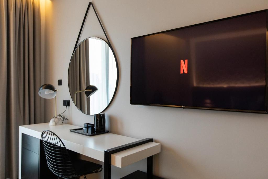 a room with a desk with a mirror and a tv at Old Port Hotel in Limassol