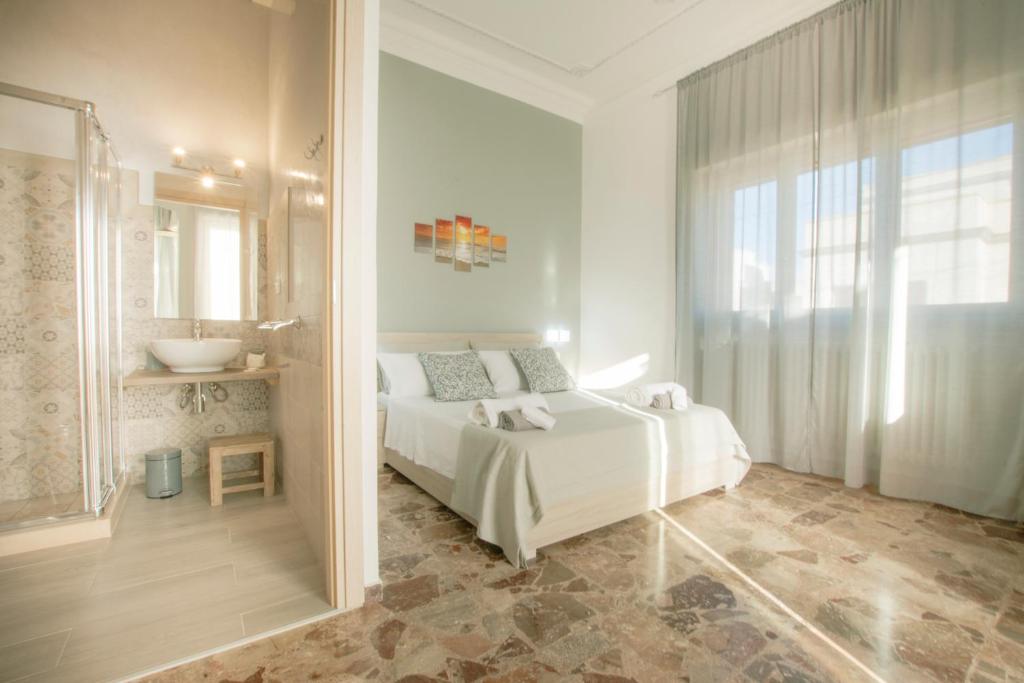 1 Schlafzimmer mit einem weißen Bett und einem Badezimmer in der Unterkunft Salento Inside in Morciano di Leuca