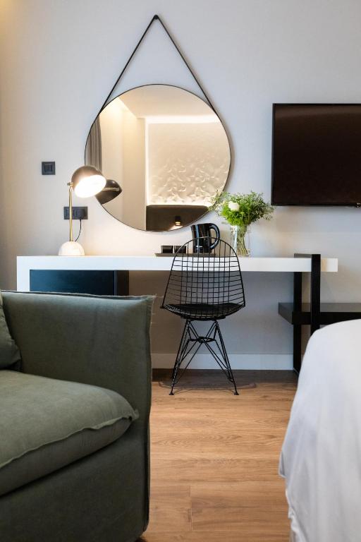 a room with a desk with a mirror and a couch at Old Port Hotel in Limassol