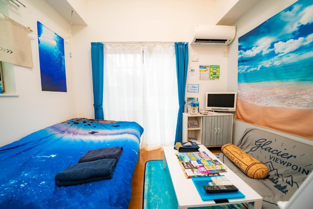 Kataseにあるレベアス片瀬江ノ島WESTのベッドとテーブルが備わる小さな客室です。
