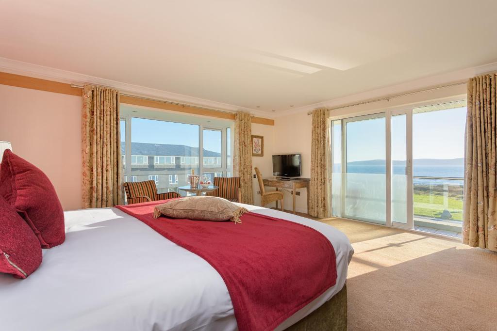 Bright bedroom with ocean view, red accents, and large windows.