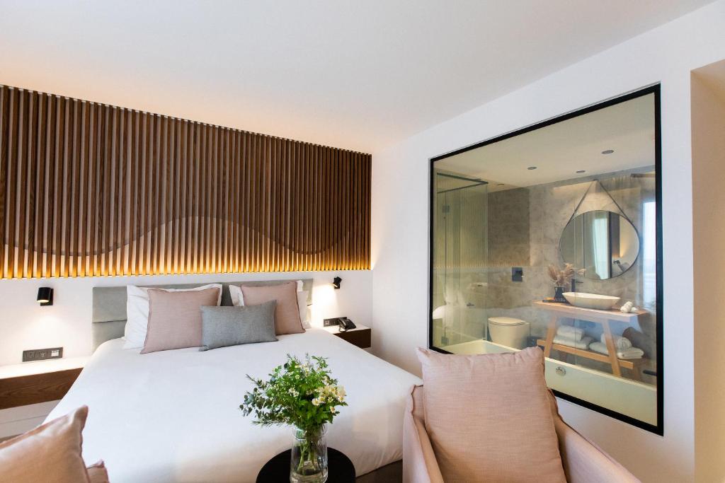 a bedroom with a white bed and two chairs at Old Port Hotel in Limassol