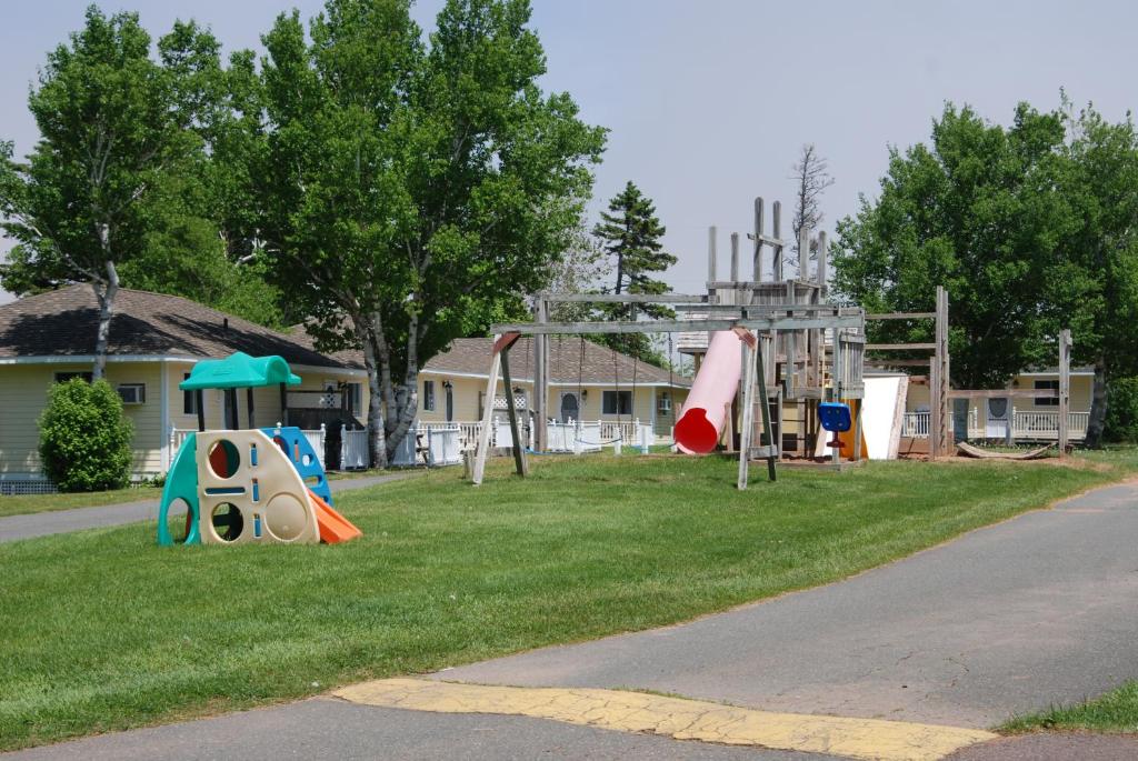 a park with a playground with slides and play equipment at Shining Waters - Ingleside Cottages in Cavendish