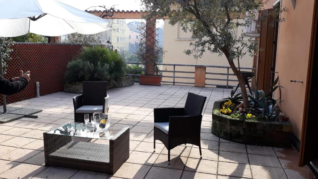 eine Terrasse mit Stühlen, einem Tisch und einem Sonnenschirm in der Unterkunft Home Scalzi 18 in Verona