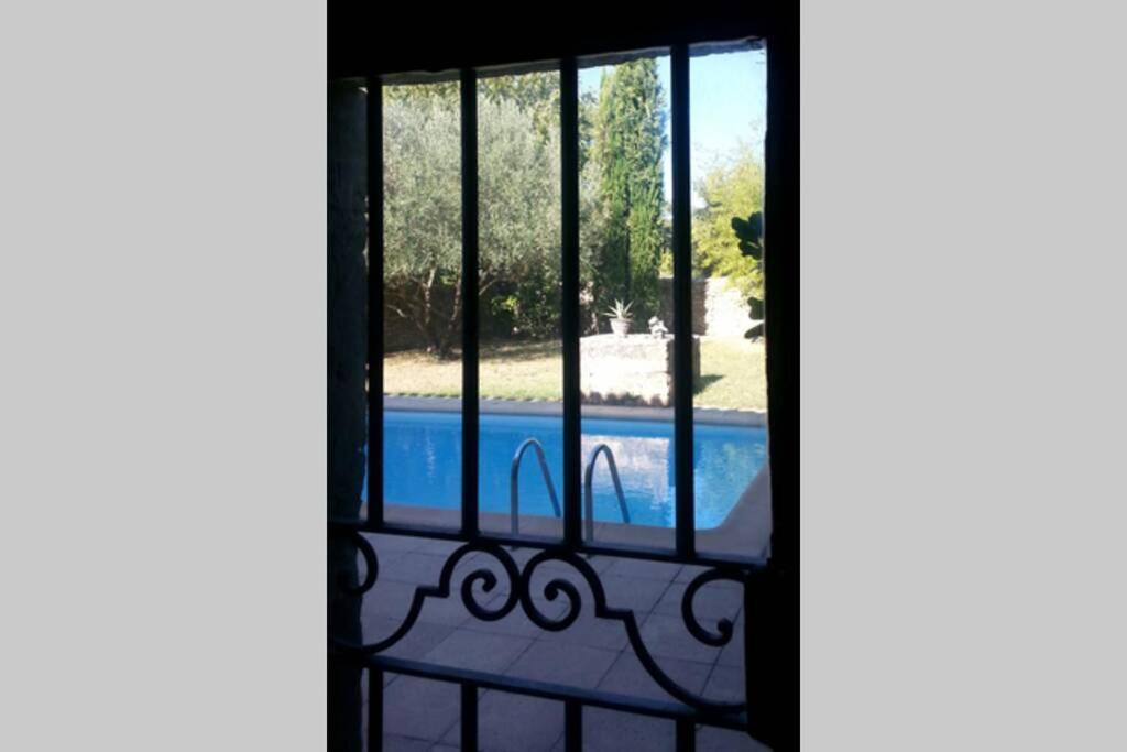 une vue d'une piscine à travers une fenêtre dans l'établissement MAS de la CHICANE, à Blauzac