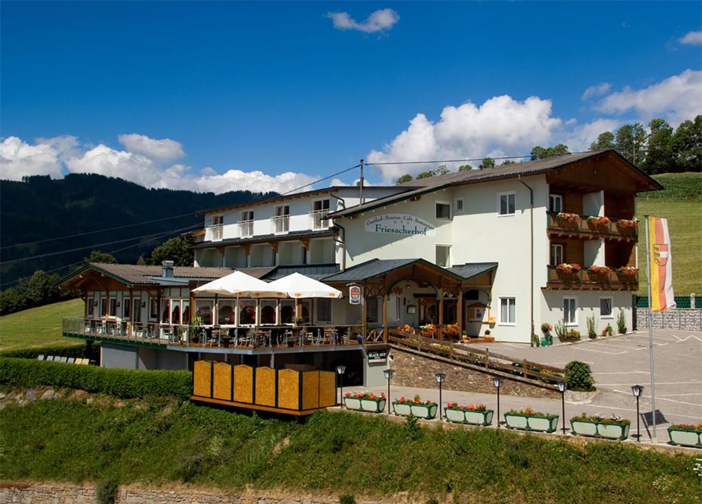 ein großes weißes Gebäude mit einem Restaurant auf einem Feld in der Unterkunft Hotel Friesacherhof in Prebl