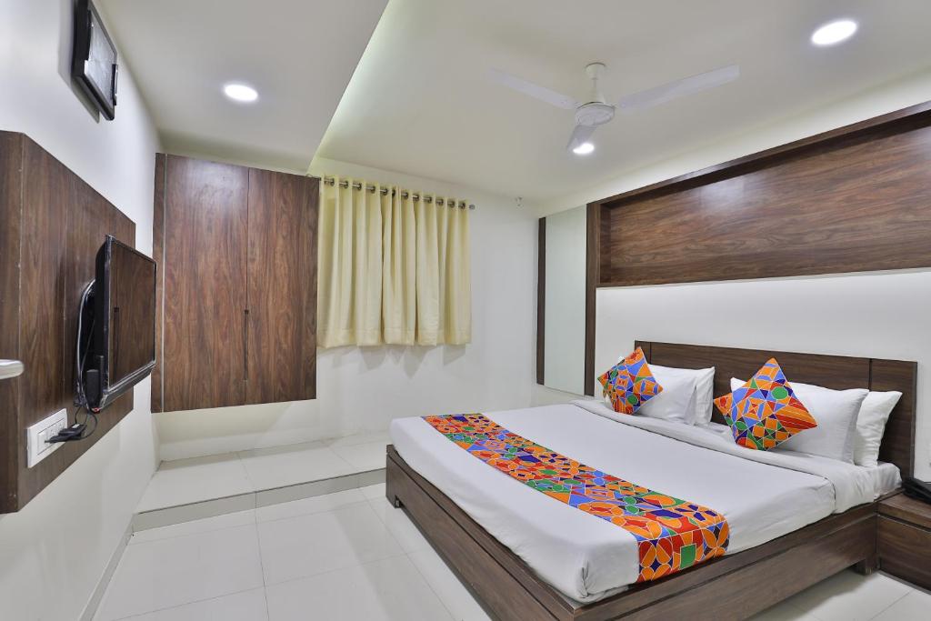 a bedroom with a bed and a flat screen tv at Hotel Nice RAILWAY STATION in Vadodara