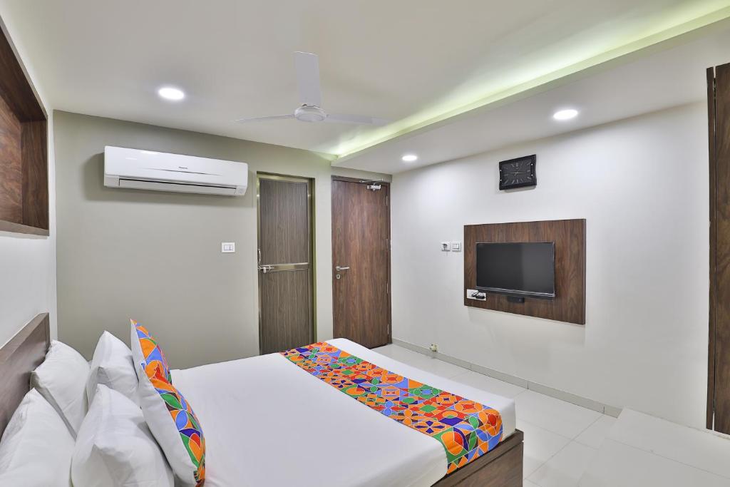 a bedroom with a bed and a tv on a wall at Hotel Nice RAILWAY STATION in Vadodara