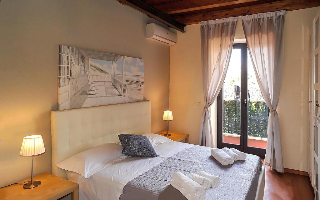 a bedroom with a bed and a large window at Katane Holidays in Catania
