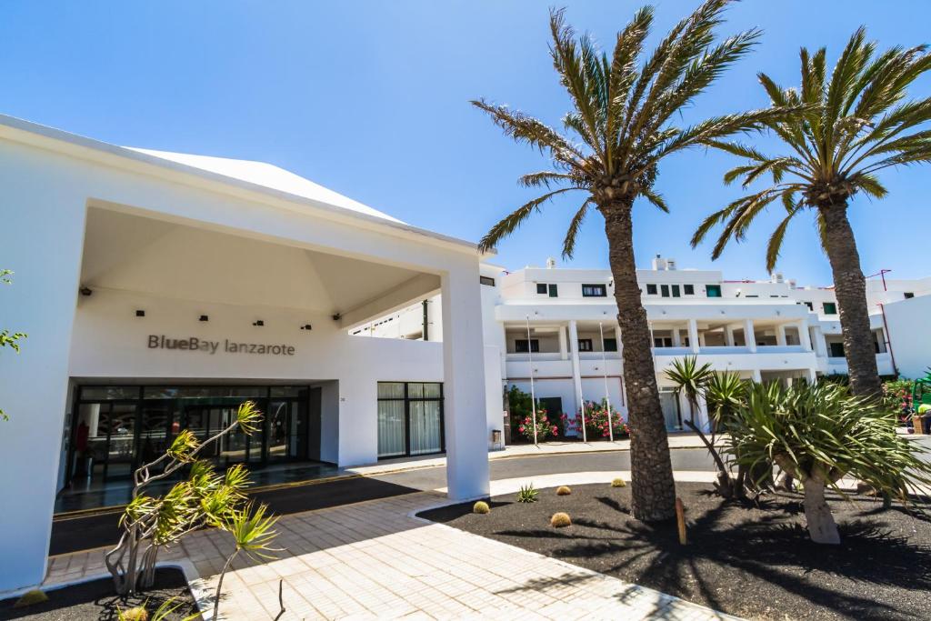 a building with palm trees in front of it at BlueBay Lanzarote in Costa Teguise