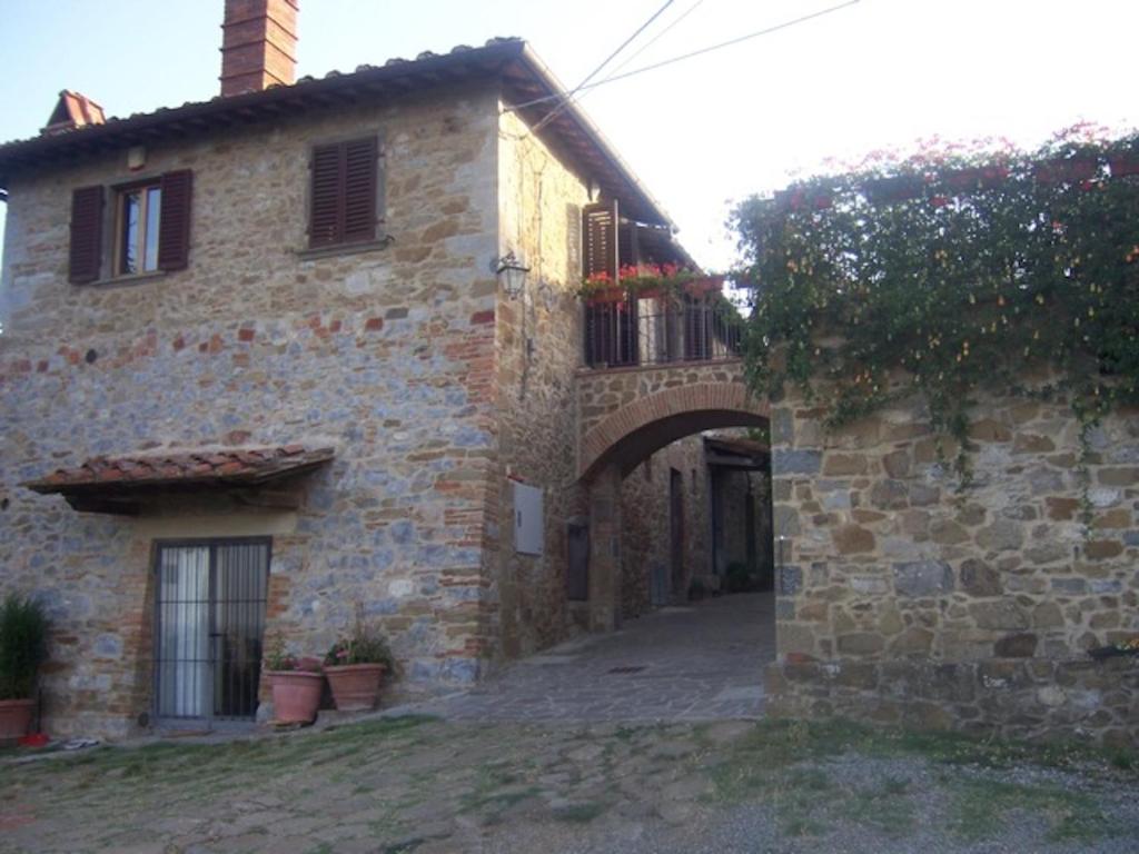 an old stone building with an archway in front of it at Villa Vittoria in Gaiole in Chianti