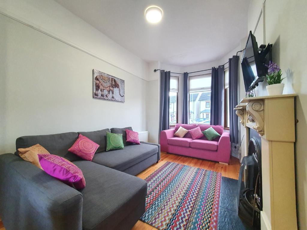 uma sala de estar com dois sofás e uma televisão em Shaftesbury Avenue Townhouse em Belfast