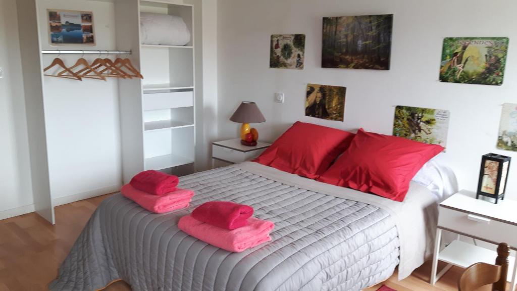 Chez Cathy في Loscouët-sur-Meu: غرفة نوم مع منشفتين ورديتين على سرير