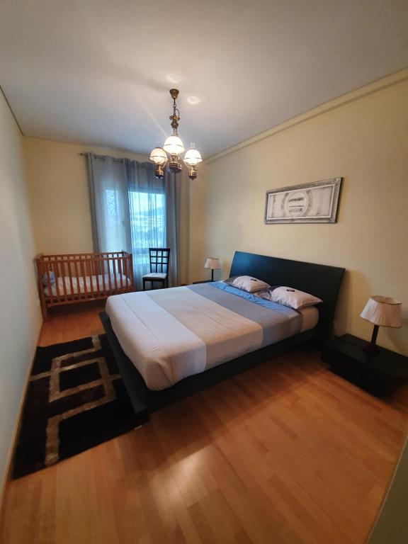 ポンタ・デルガダにあるApartamento T3 Ponta Delgadaのベッドルーム1室(大型ベッド1台、シャンデリア付)