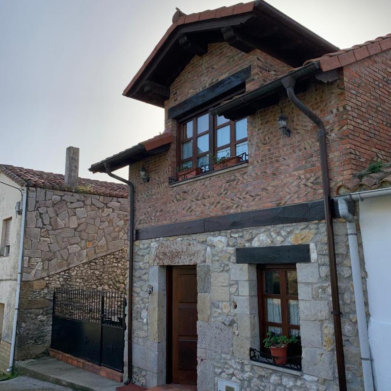 a brick house with windows and a roof at Casa Cuco in Serdio