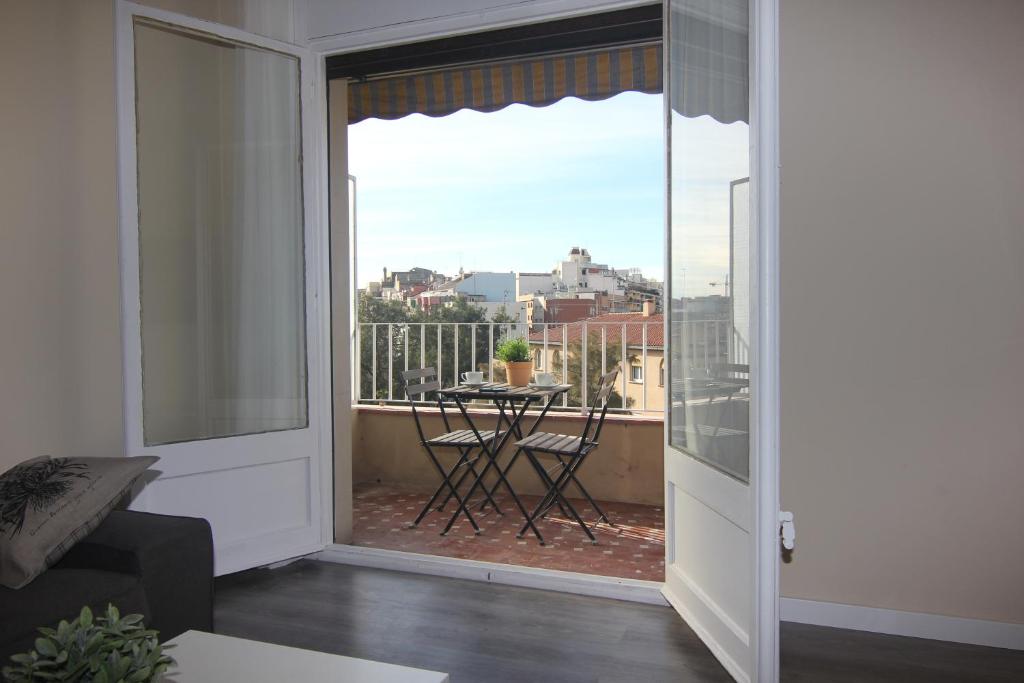 a room with a view of a balcony with a table at FELIP II - Spacious and quiet apartments in Barcelona