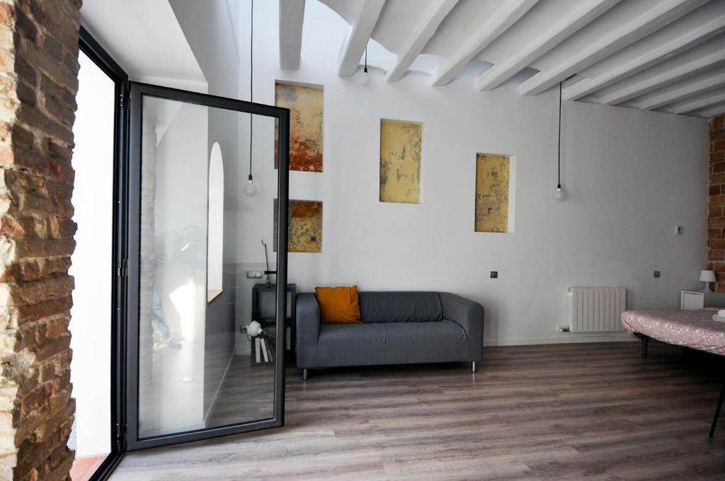 salon z kanapą i lustrem w obiekcie Apartamento en Vilanova w mieście Vilanova i la Geltrú