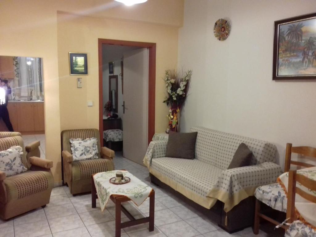 a living room with couches and chairs and a table at George's & Amalia's appartments in Afantou